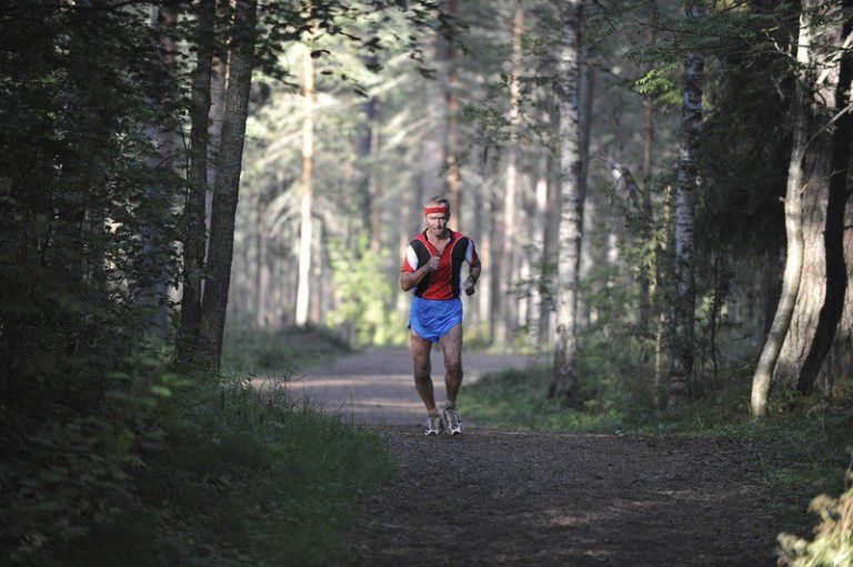 Läufer über 60 bei einem lockeren Lauf auf einem Waldweg