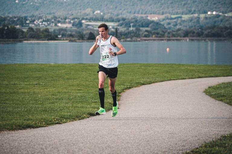 Läufer trinkt Wasser bei großer Hitze beim RunMotion Coach Marathon in Chambéry am Lac du Bourget