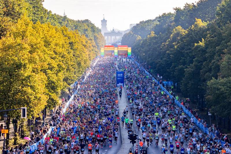 Läufer beim Berlin-Marathon auf der Strecke, Fokus auf Anmeldung, Training und persönliche Bestzeit.