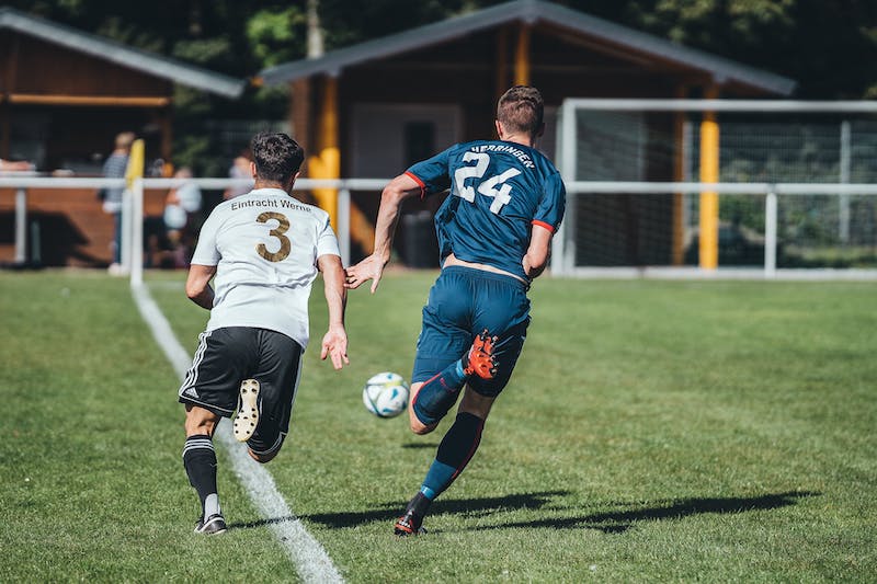 Spieler beim Fussball-Ausdauertraining mit Lauftraining sowie Kraft- und Konditionseinheiten ueber 90 Minuten.