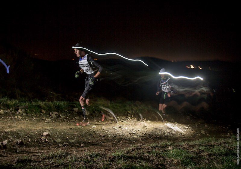 Trailrunner beim Nachts laufen mit Stirnlampe, fokus auf Sicherheit und klare Sicht im Dunkeln.