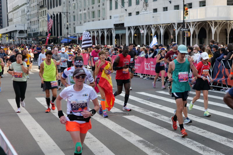 Laufende Athletinnen und Athleten beim New York City Marathon 2023, beeindruckende Fotos von RunMotion Coach.