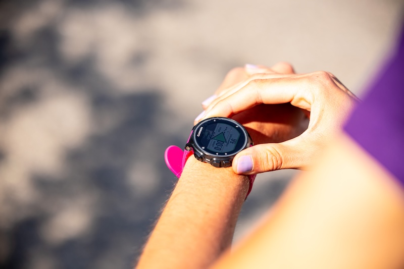 Läuferin prüft GPS-Uhr beim ersten 10-km-Lauf und verfolgt Tempo sowie Distanz.